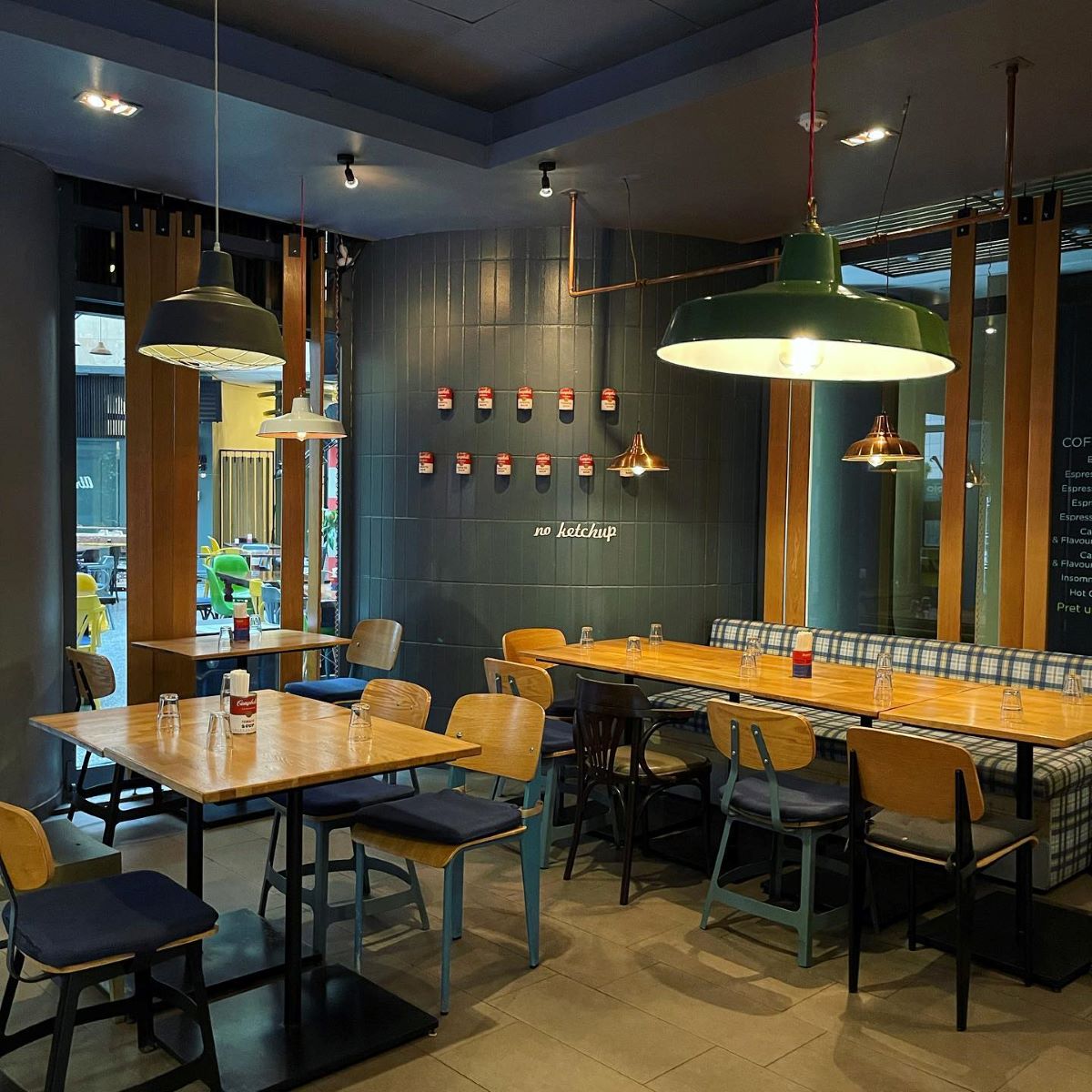 mai multe mese si scaune de restaurant sunt asezate in interiorul unui bar din Bucuresti care organizează petreceri de secret santa