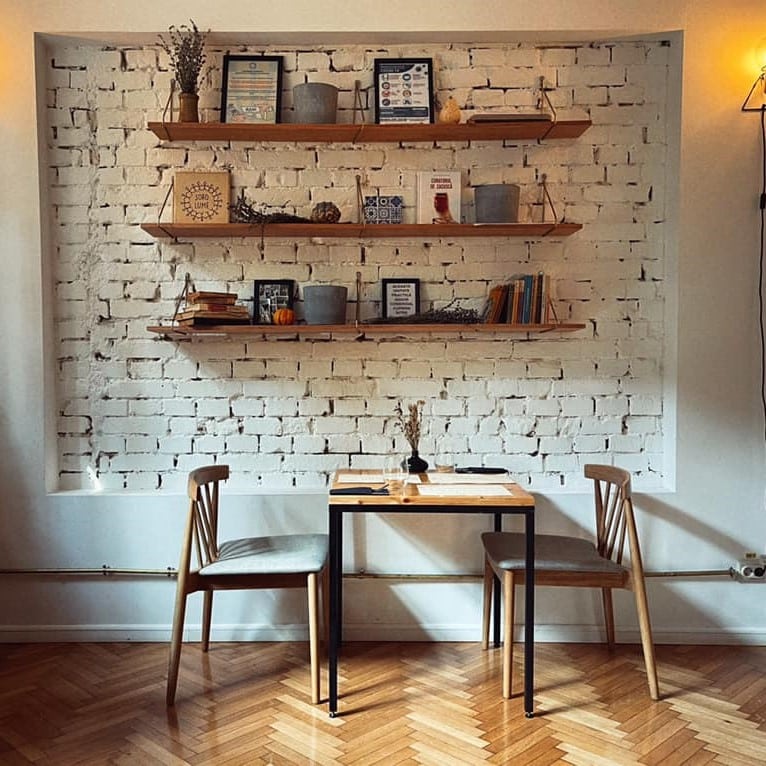 masa cu 2 scaune in dreptul unor rafturi cu carti la soro lume