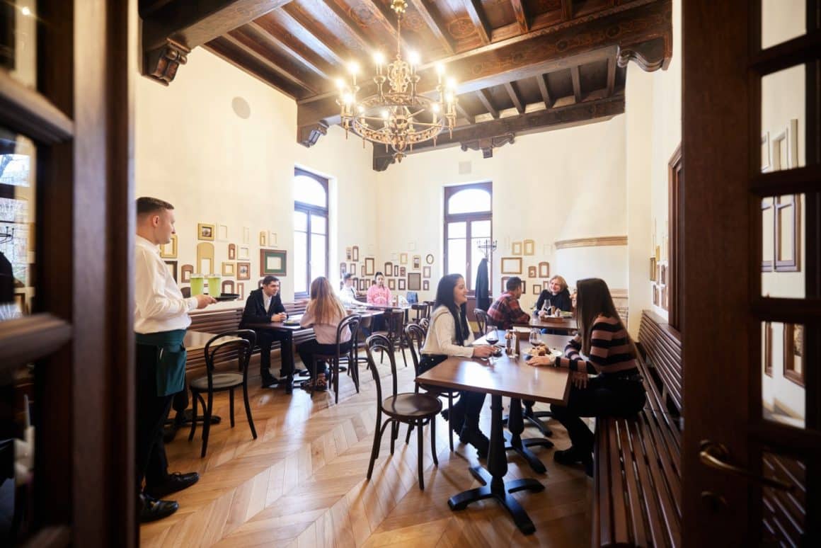 oameni iau masa la Hanu Berarilor Casa Oprea Soare, casa boiereasca, in stil neoromânesc