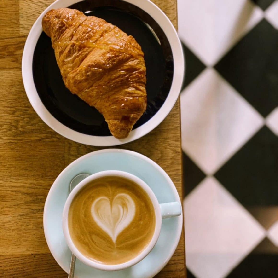 ceasca de cafea si croisant de la Saint Roastery 