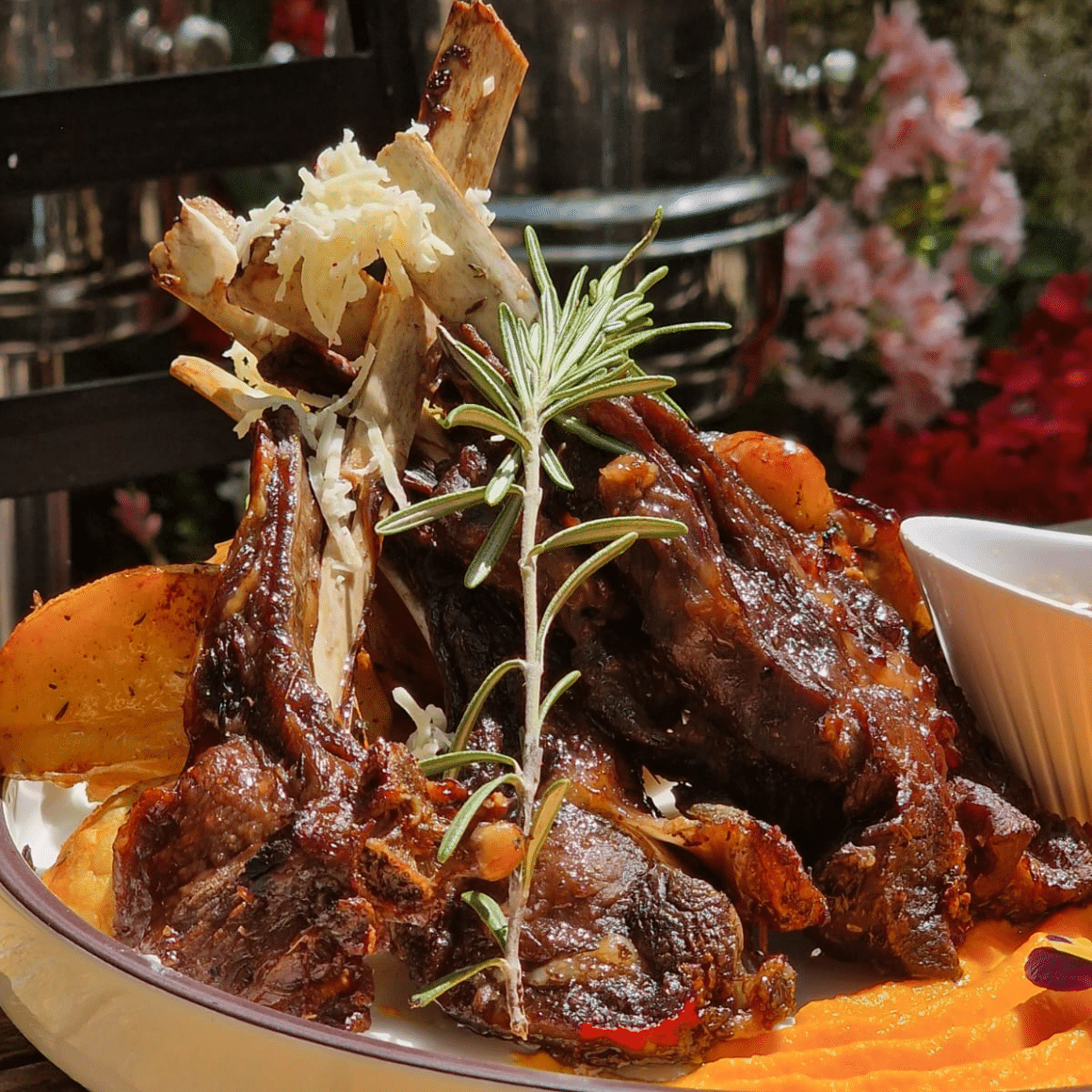 un ciolan de porc cu cartofi, într-un bol mare, așezat pe o masă înrestaurant