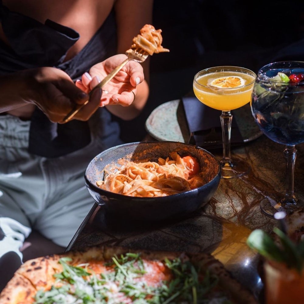 femeie mananca paste dintr-o farfurie