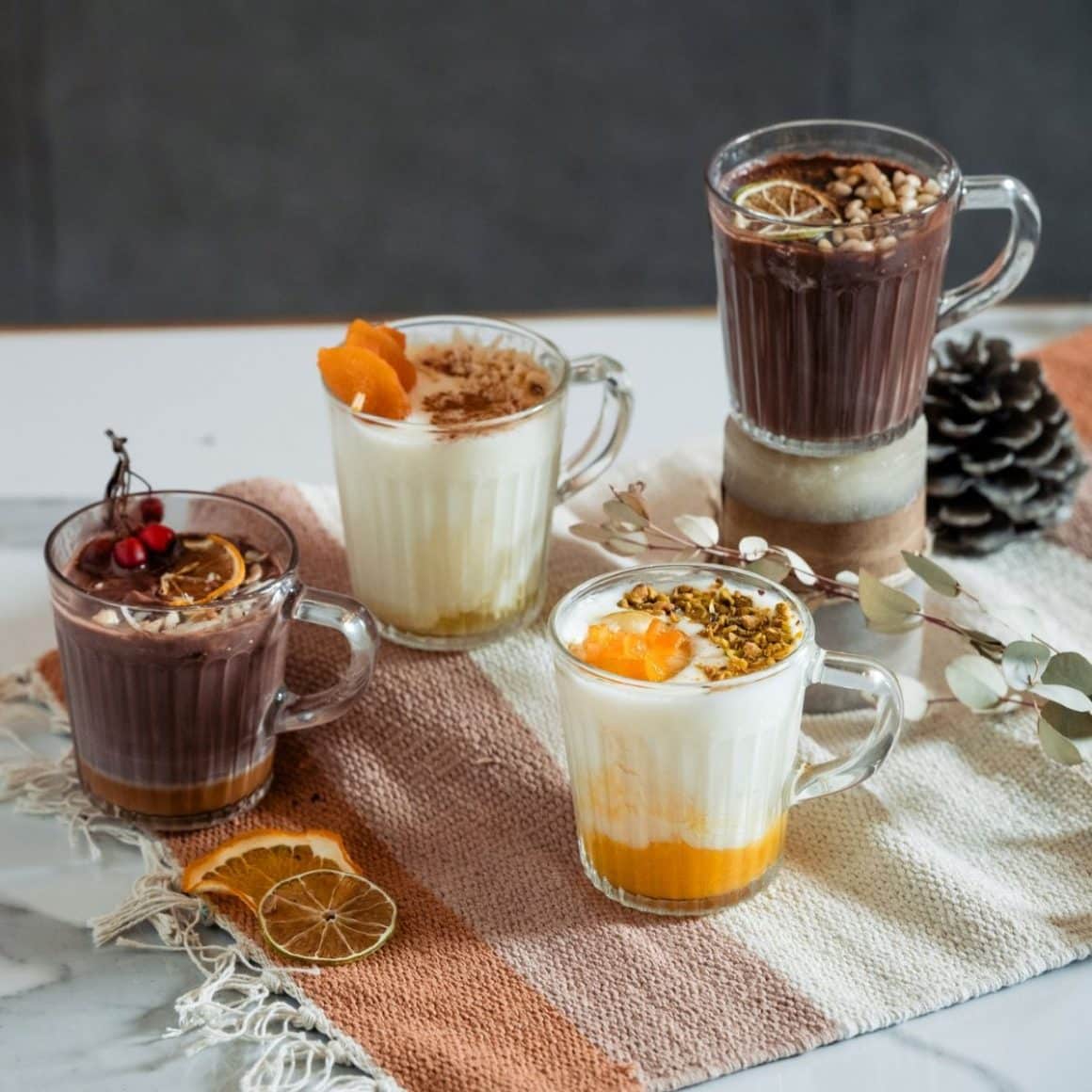 patru căni transparente, cu băuturi calde de toamnă