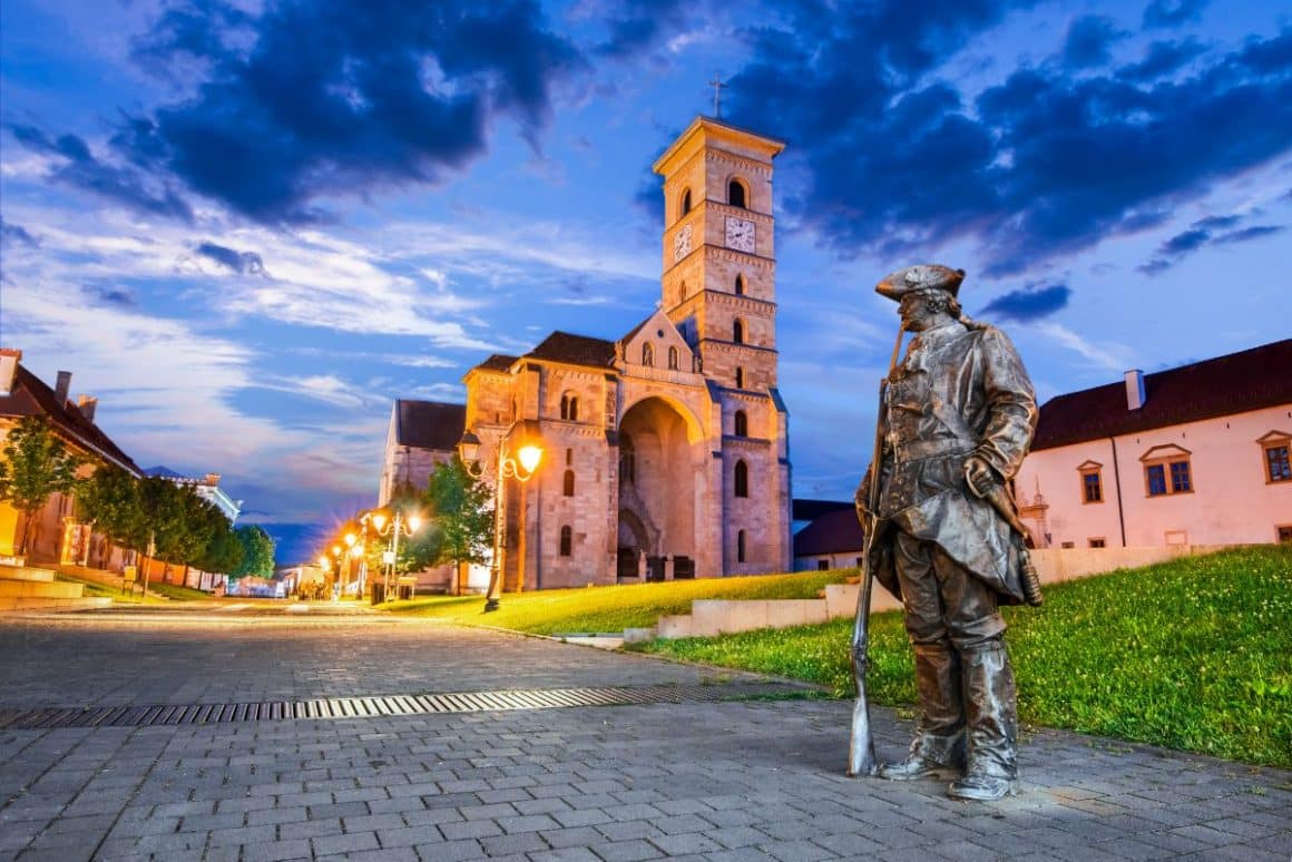o statuie din bronz reprezentând un soldat austro-ungar este fotografiata la apus, in interiorulc etății alba iulia