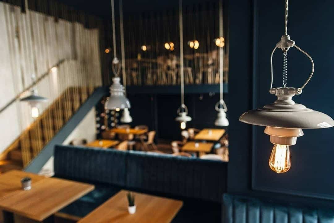 prim plan cu un corp de ilumnait de la Haute Pepper, iar in fundal interiorul restaurantului, blurrat. Unul din restaurante cozy din București