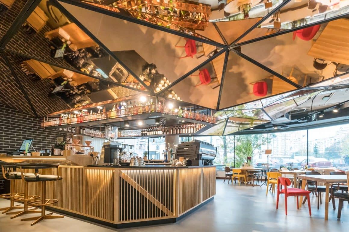 interiorul unui bar din bucuresti cu mobilă din lemn masiv și multe oglinzi pe tavan