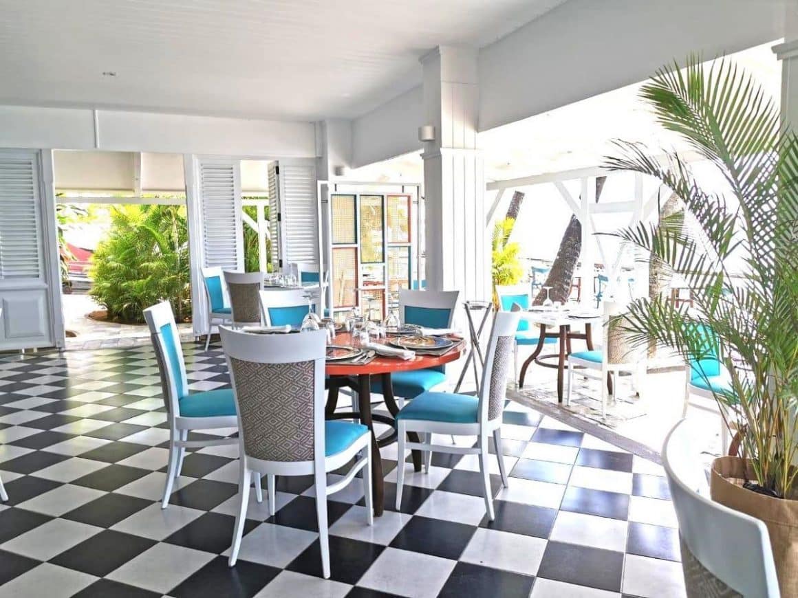 mai multe scaune sunt asezate in jurul unei mese pe terasa unui hotel din mauritius