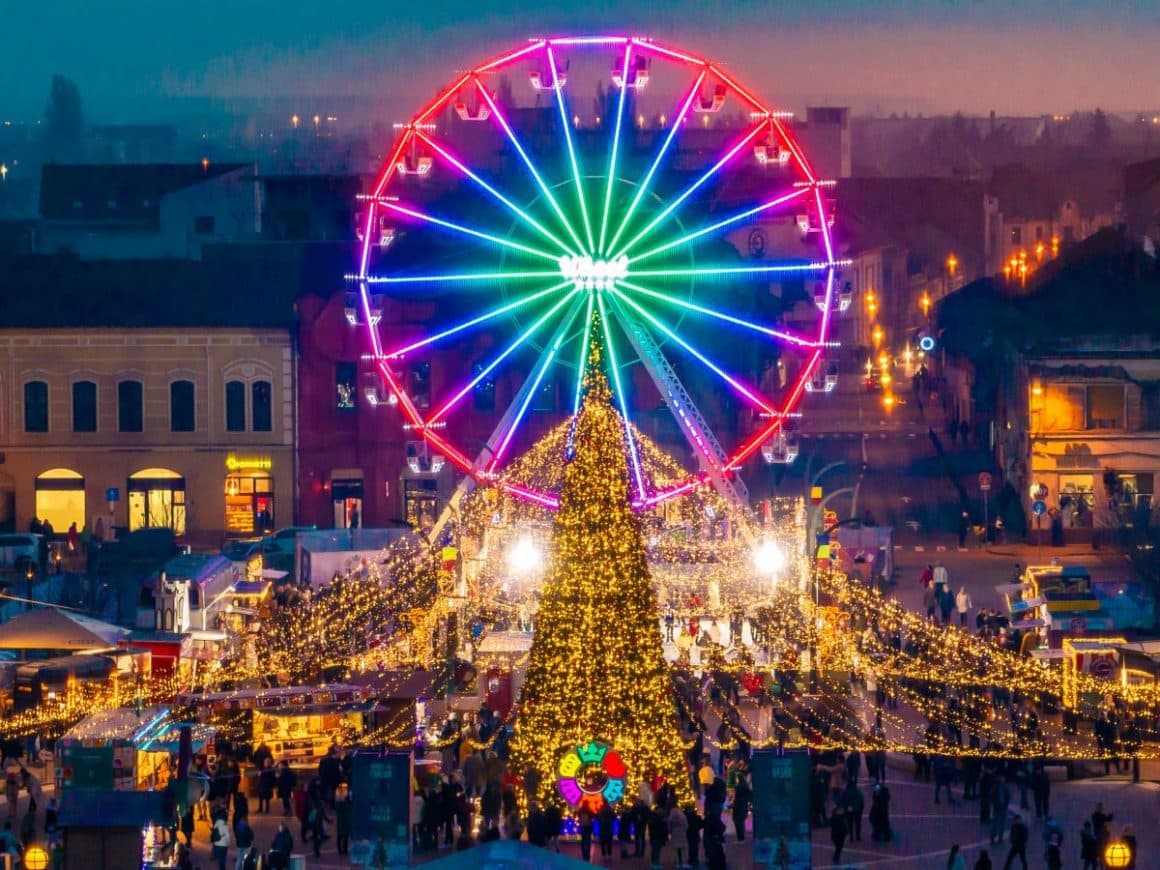 o fotografie aeriana panoramică cu targul de craciun din oradea și o roată mare, luminată