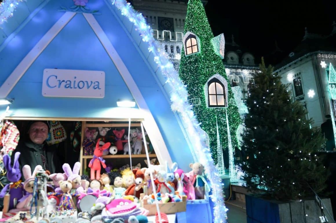 intrarea in târgul de crăcun de la craiova, cu o căsuță și doi brazi împodobiți