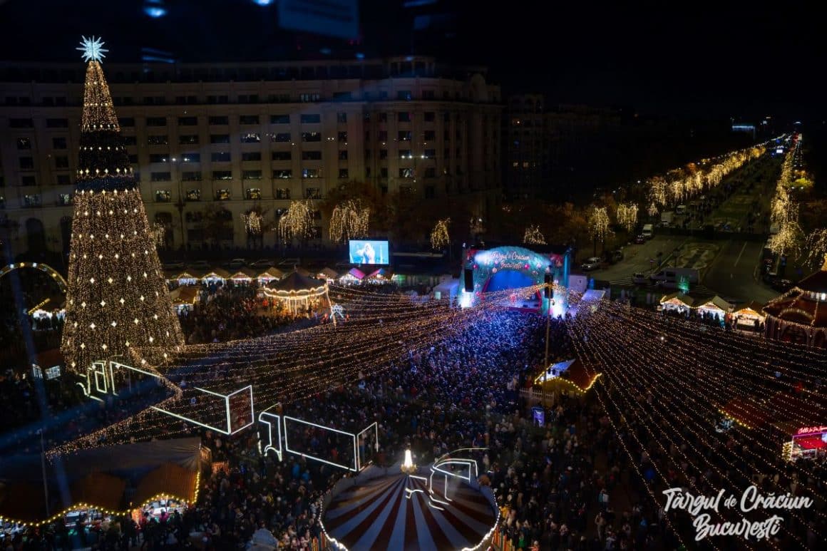 o fotografie aeriană a targului de craciun din piata constituției, cu luminițe și casuțe, unul dintre cele mai frumoase targuri de craciun din romania