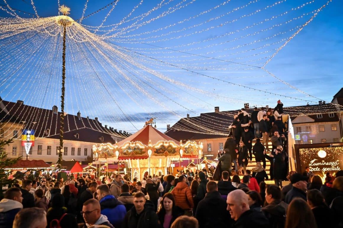 o fotografie aeriană a targului de craciun din piata constituției, cu luminițe și casuțe, unul dintre cele mai frumoase targuri de craciun din romania