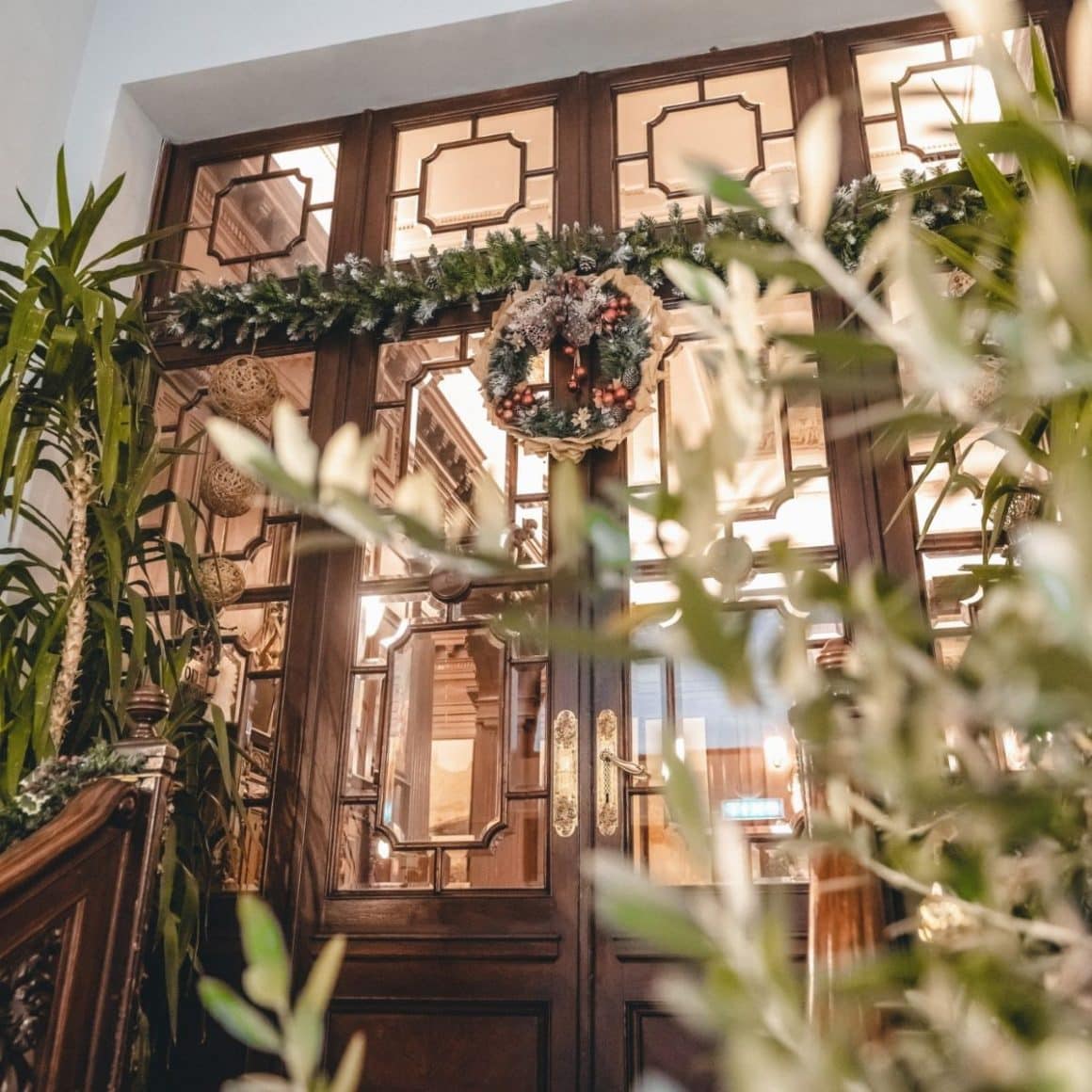 o coroniță de crăciun este agățată de ușa de la intrarea în restaurantul Ciao Niki