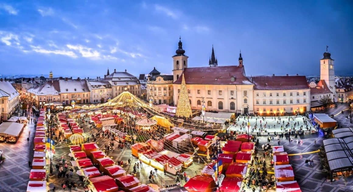 o fotografie aeriană a targului de craciun din Sibiu, cu luminițe și casuțe, unul din cele mai frumoase târguri de Crăciun din România 2023