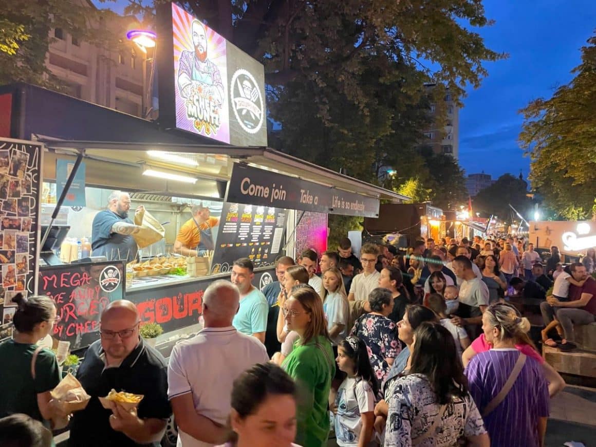 mai multi tineri stau la coadă la un food truck la festival 