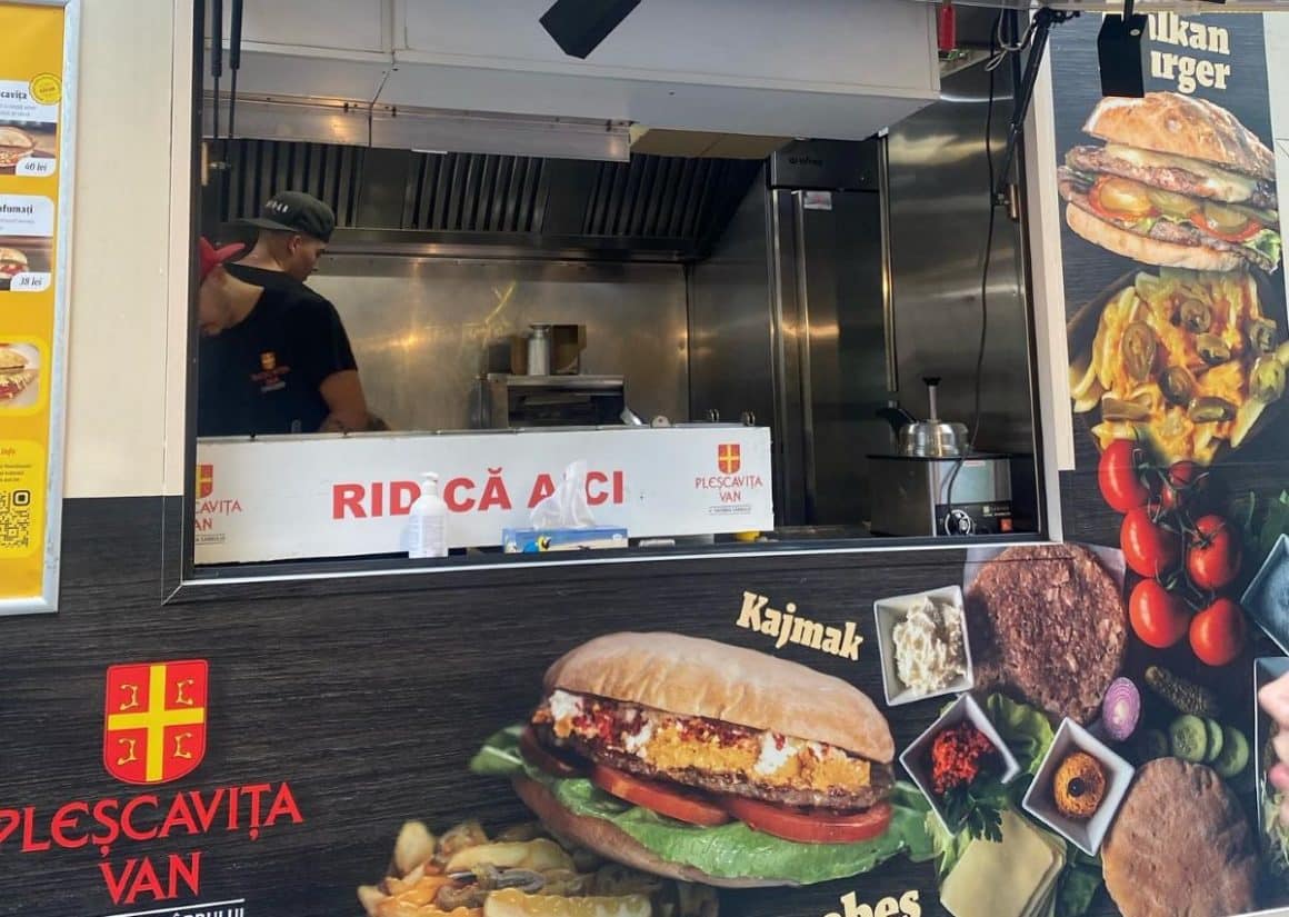 un brabrat prepară o potrie de mancare la un festival gastronomic, într-un food truck