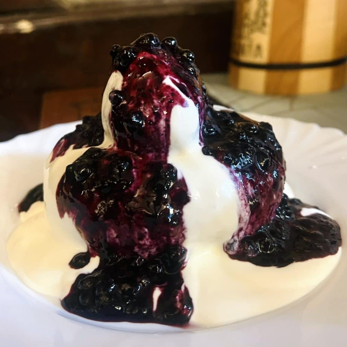 close up cu un papanas mare, acoperit de smantana si dulceata