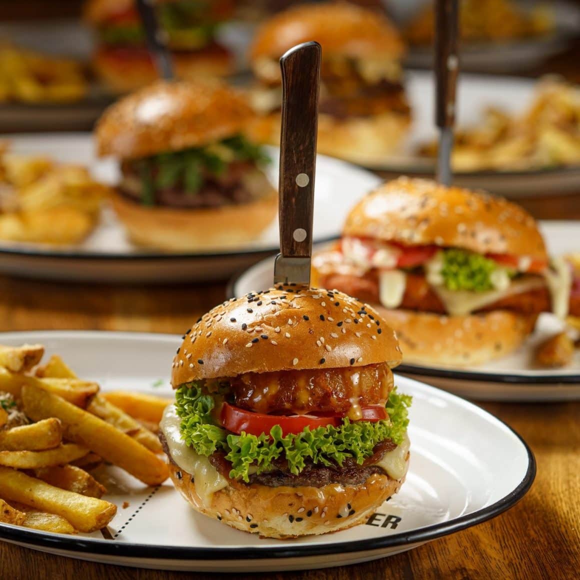 mai multe farfurii cu burgeri si cartofi prăjiți de la Modelier. Unde mâncăm ieftin și bun în București