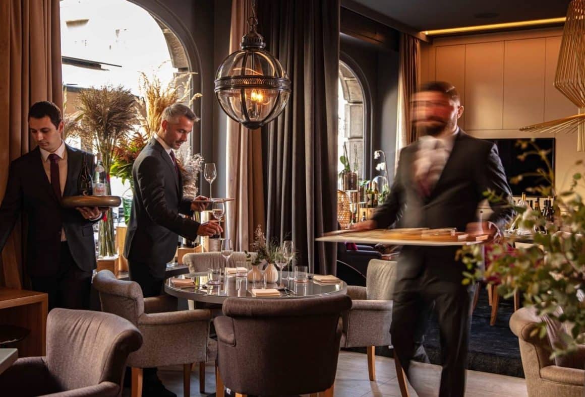 mai multi ospatari eleganti servesc masa intr-un restaurant elegant la Noel, Zagreb