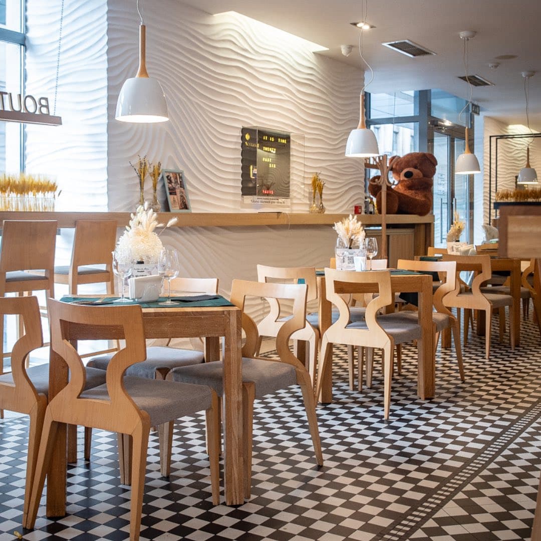 mese si scaune din lemn, intr-und ecor predominant alb, la Boutique Du Pain București