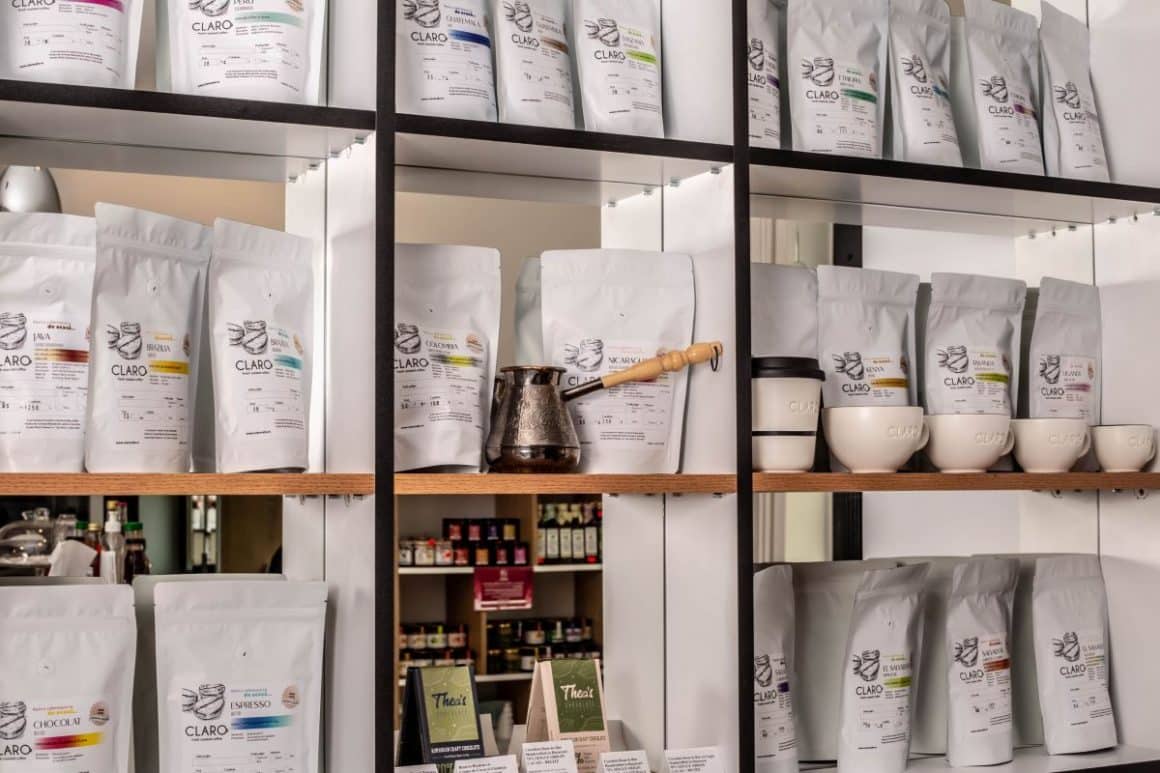 rafturile unei prăjitorii de cafea, cu mai multe pachete de cafea vidate ți un ibric