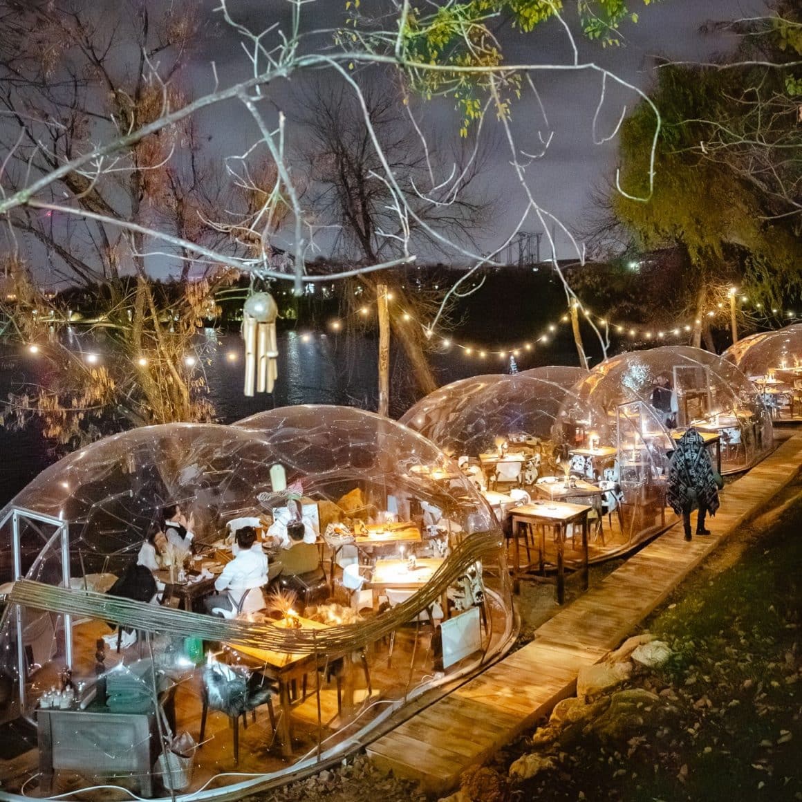 terasa de la Indigen Space for soul Bucuresti, cu igluu pe malul lacului, fotografiate seara, cu oameni care iau masa