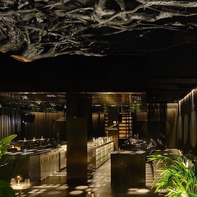 Interiorul luxos si elegant din barul MOSH Bucuresti, decorat cu mult auriu, fotografiat in semiintuneric