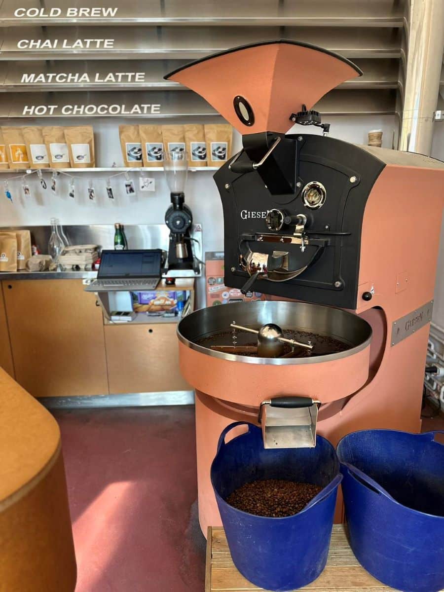 un aparat de prăjit cafeaua este așezat in interiorul unei prăjitorii de cafea din București