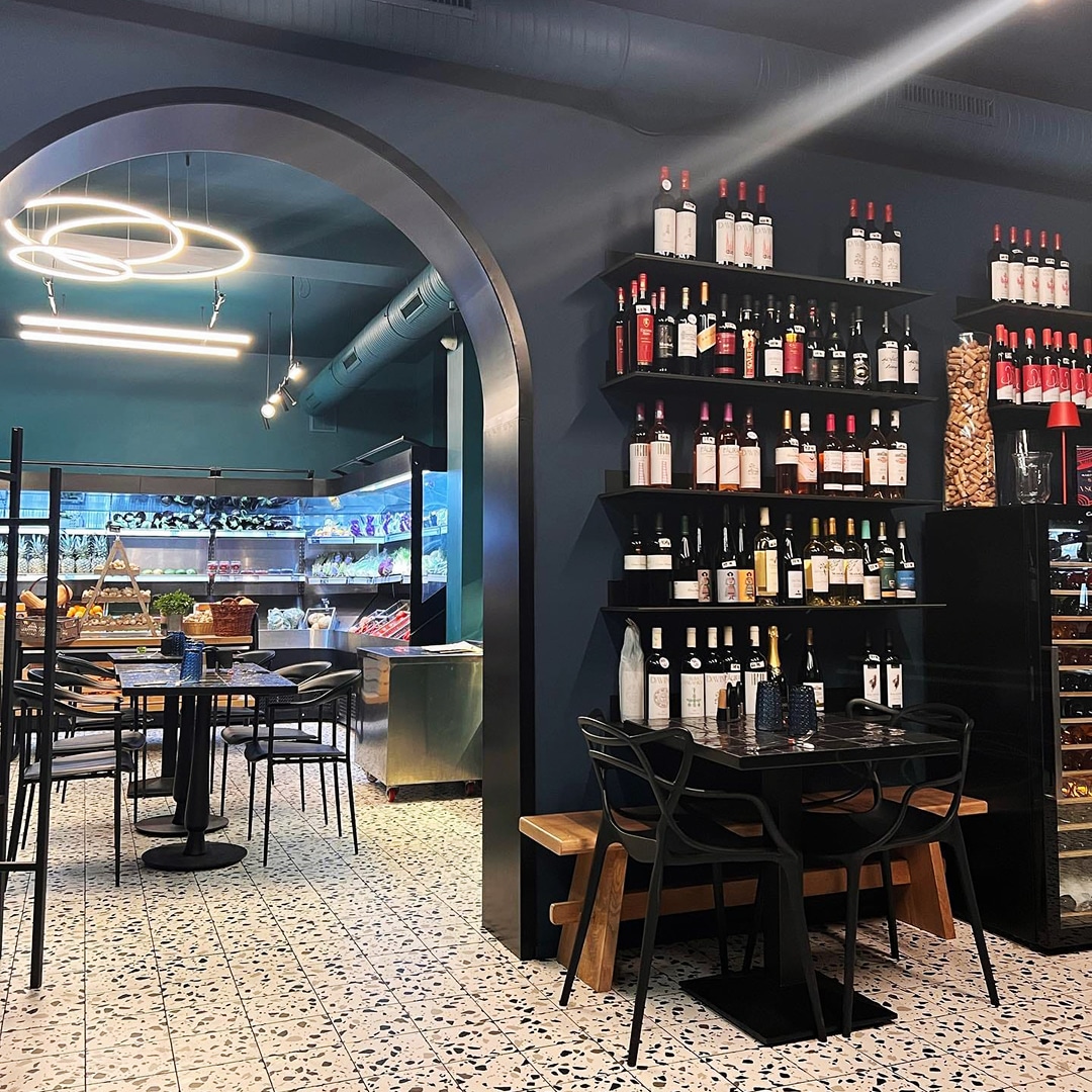 Interiorul de la Rual, cu mese si in fundal aprozarul