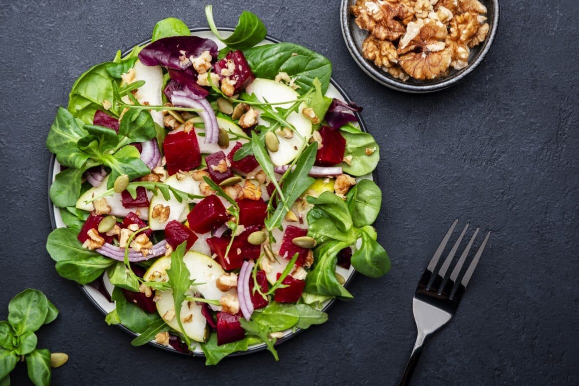 o farfurie albă, rotundă, cu mai multe ingrediente folosite la prepararea unei salate calde salate calde