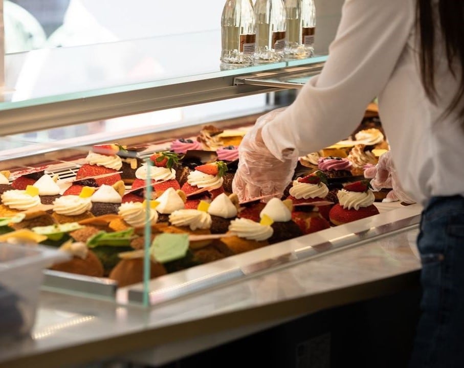 Vitrina de cofertarie, plina cu choux-uri de mai multe sortimente si culori