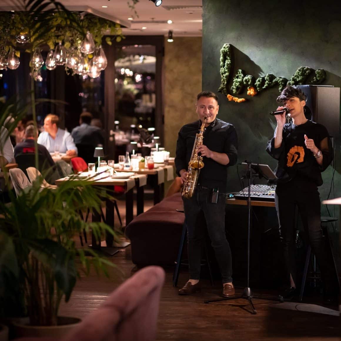 un saxofonist si o cantareata performeaza live music la 18 Lounge. 