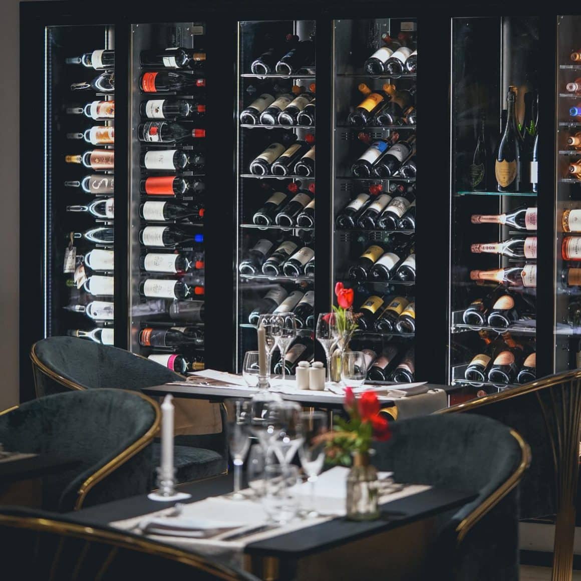 mese in dreptul unor frigidere pline cu sticle de vin