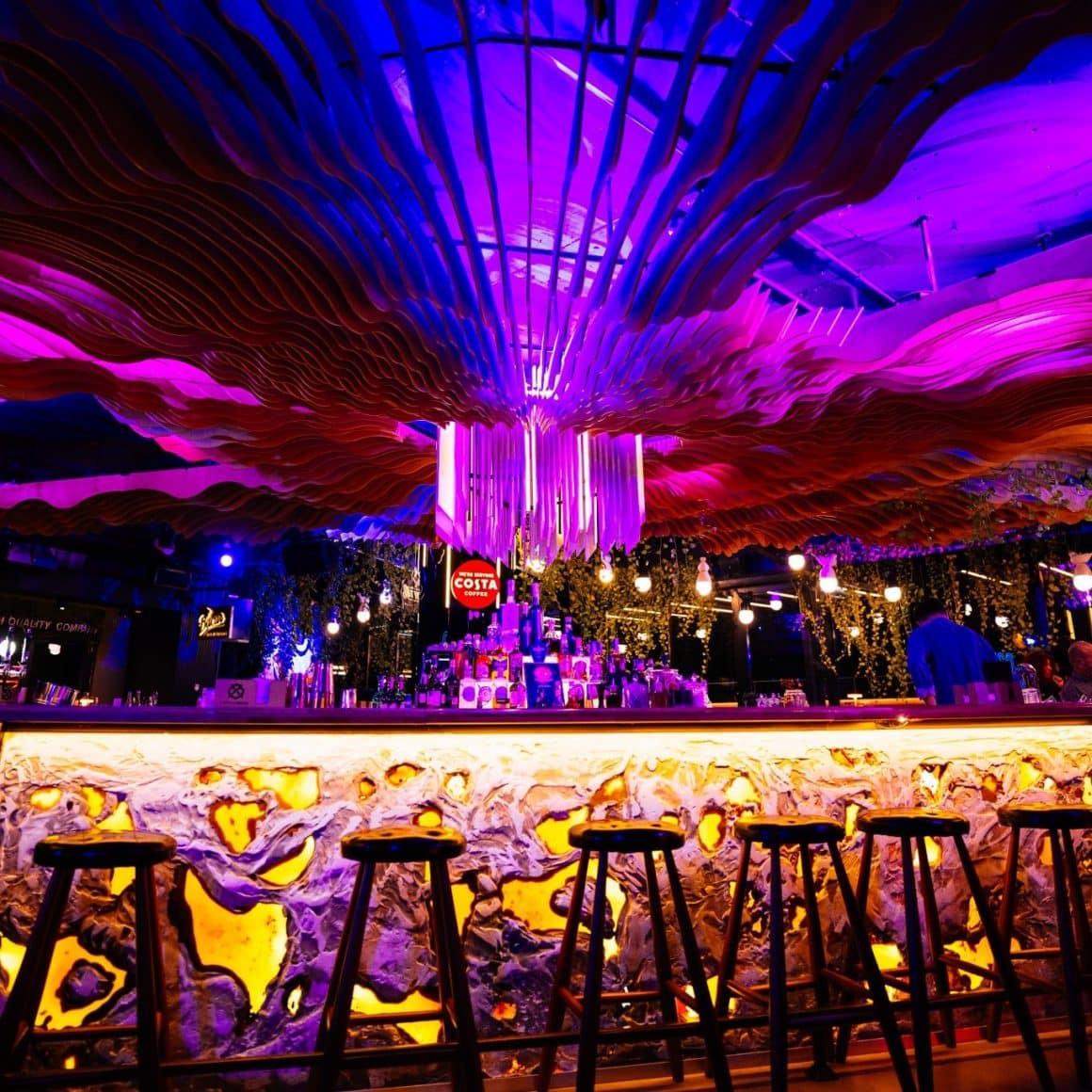 Barul elegant, iluminat in mov si auria, de la Naive București