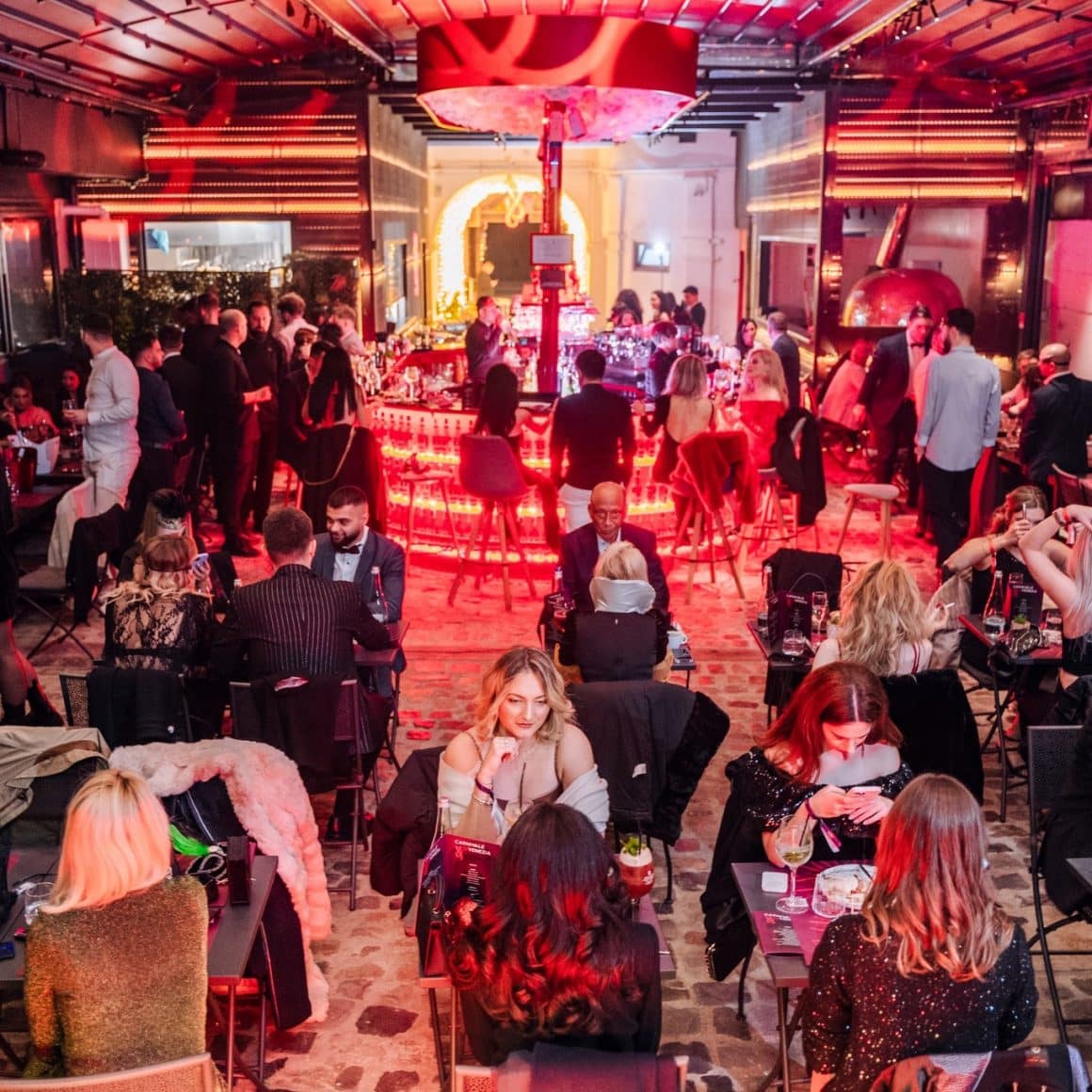 mai multi oameni servesc masa intr-un restaurant cu lumina rosie. Innocent and Delicious Bucuresti. Restaurante 8 martie