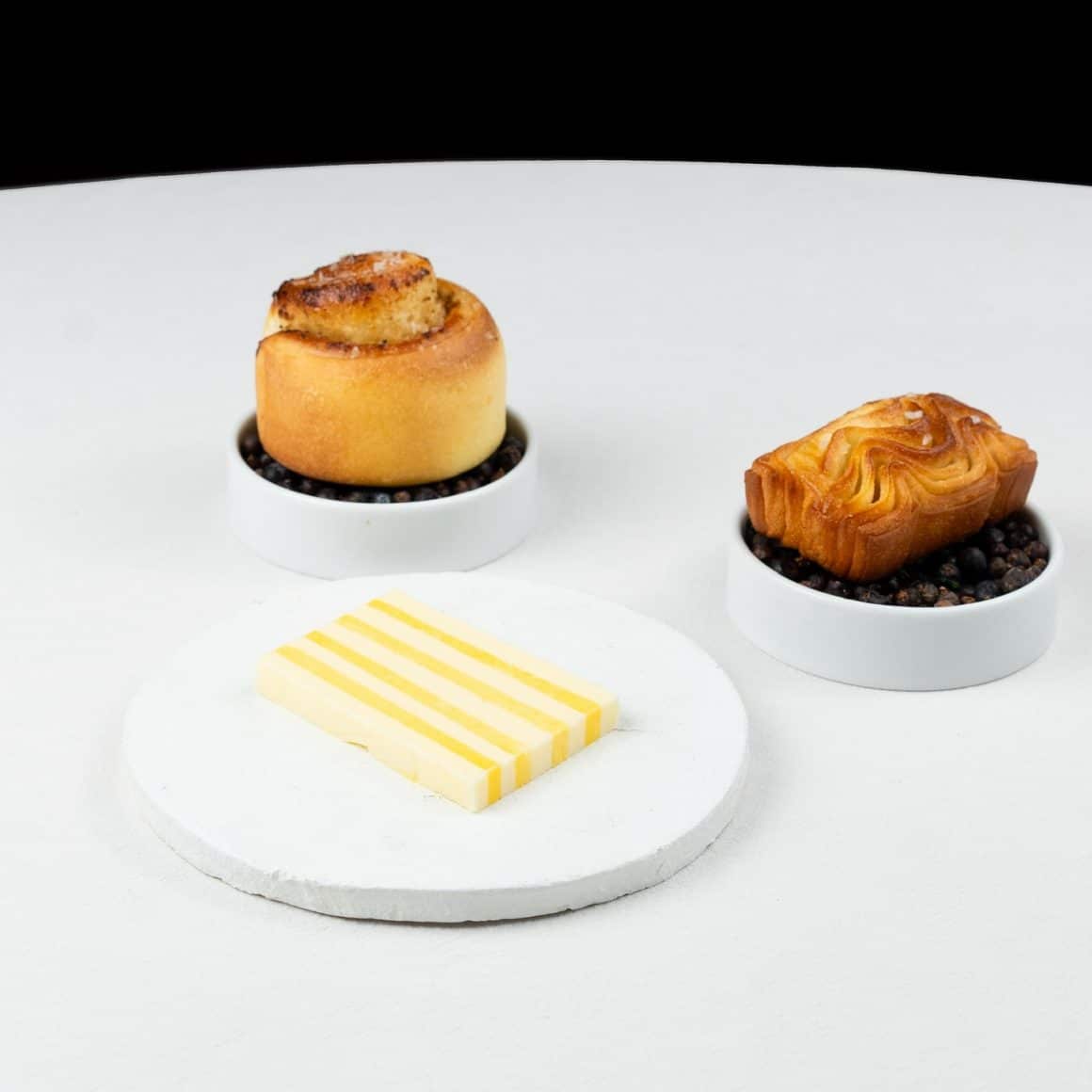 3 preparate de fine dining fotografiate pe o masa alba