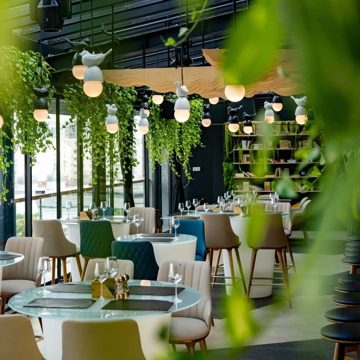 mai multe mese in fata geamurilor mari, cu priveliste panoramica asupra Bucurestiului, la Naive restaurant