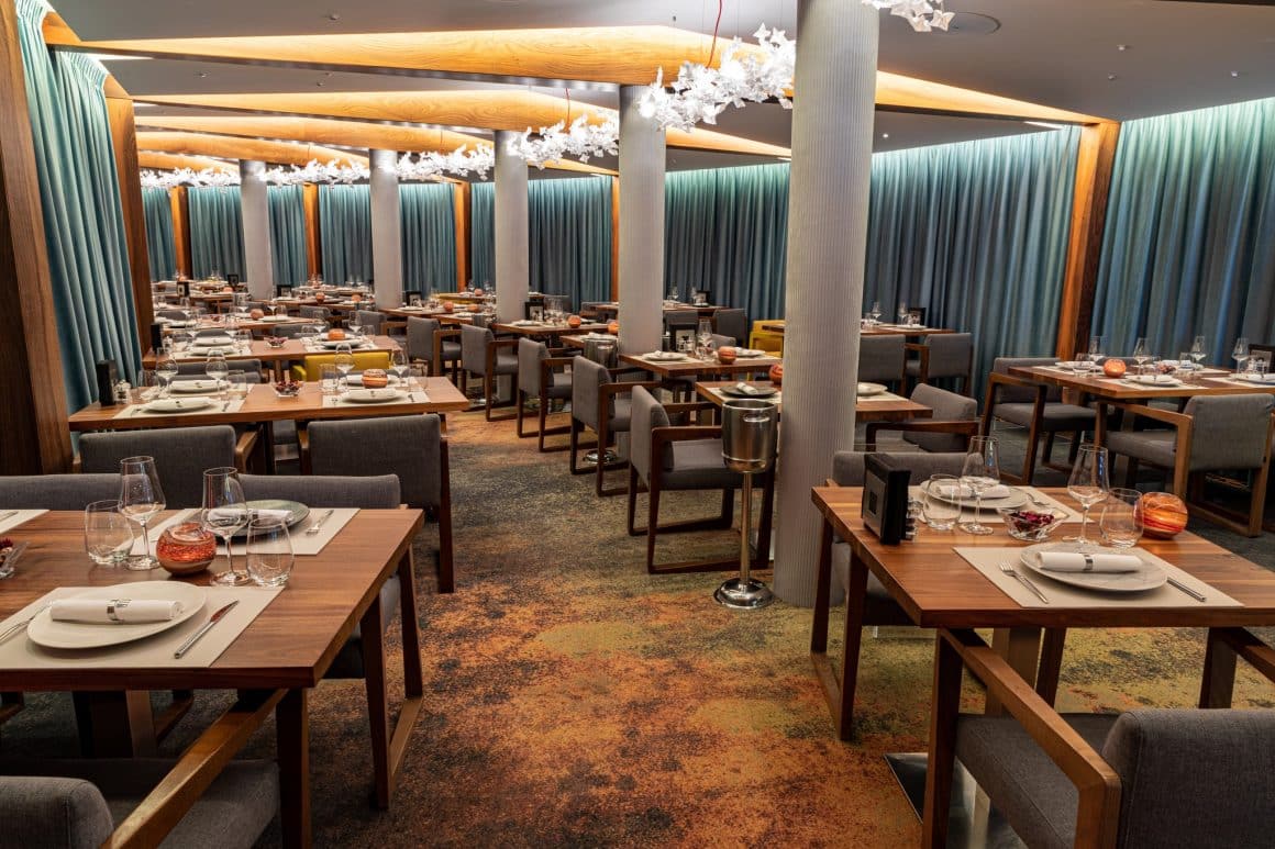 imagine de ansamblu din restaurant casa di david, cu mese de restaurant din lemn si scaune tapitate gri, si draperii grele, din catifea bleu. Restaurante unde sa mergi la prima întâlnire