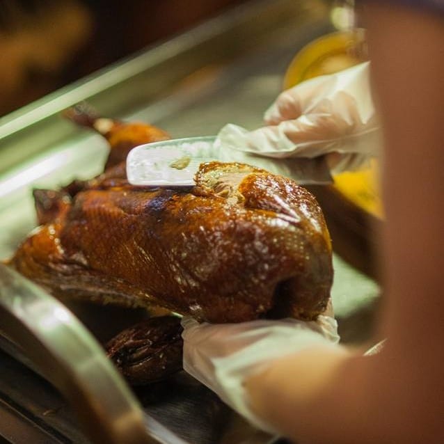 close uop cu bucatar care taie o rata peking