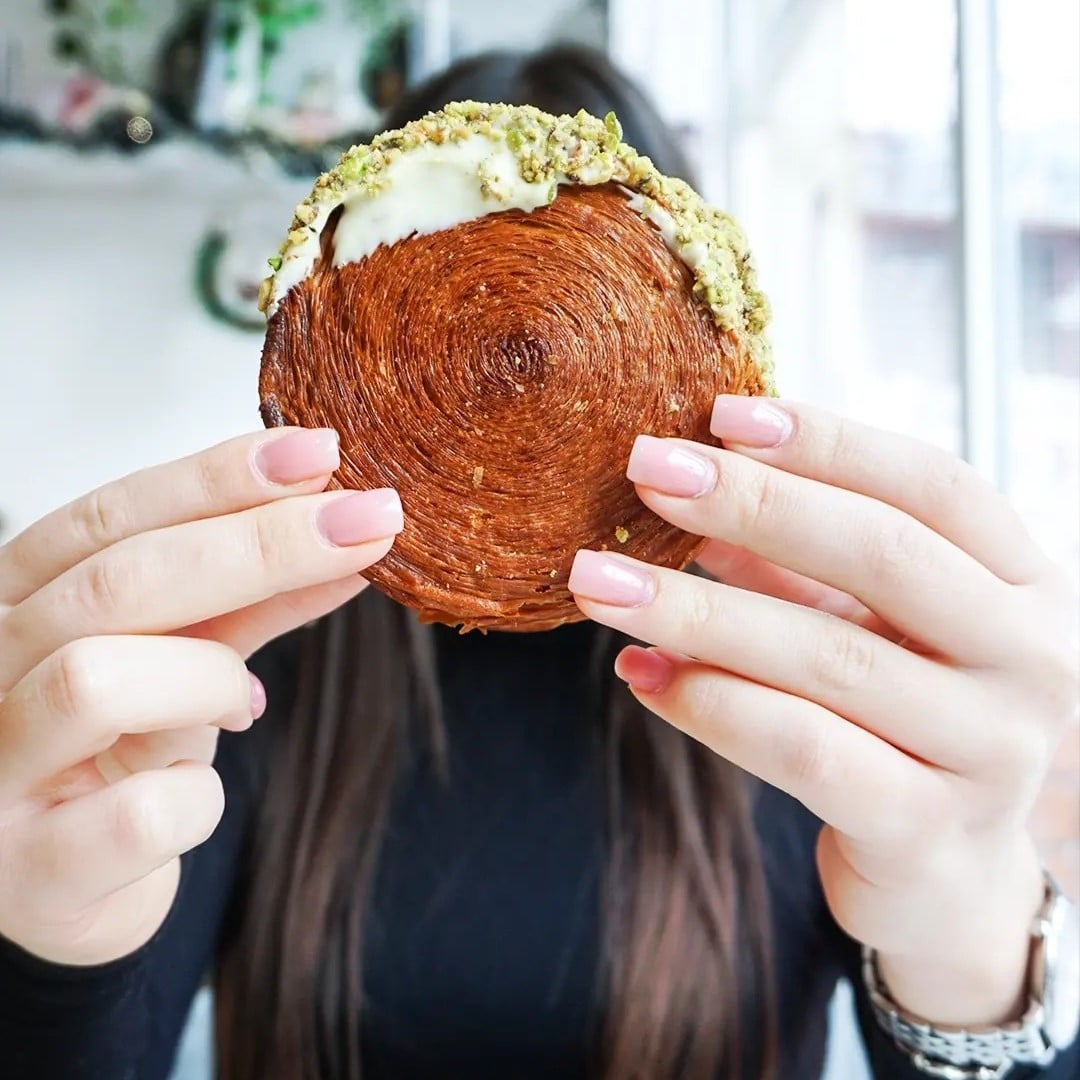 o fata tina in mana, in dreptul fetei, un new york roll de la angeline cake boutique