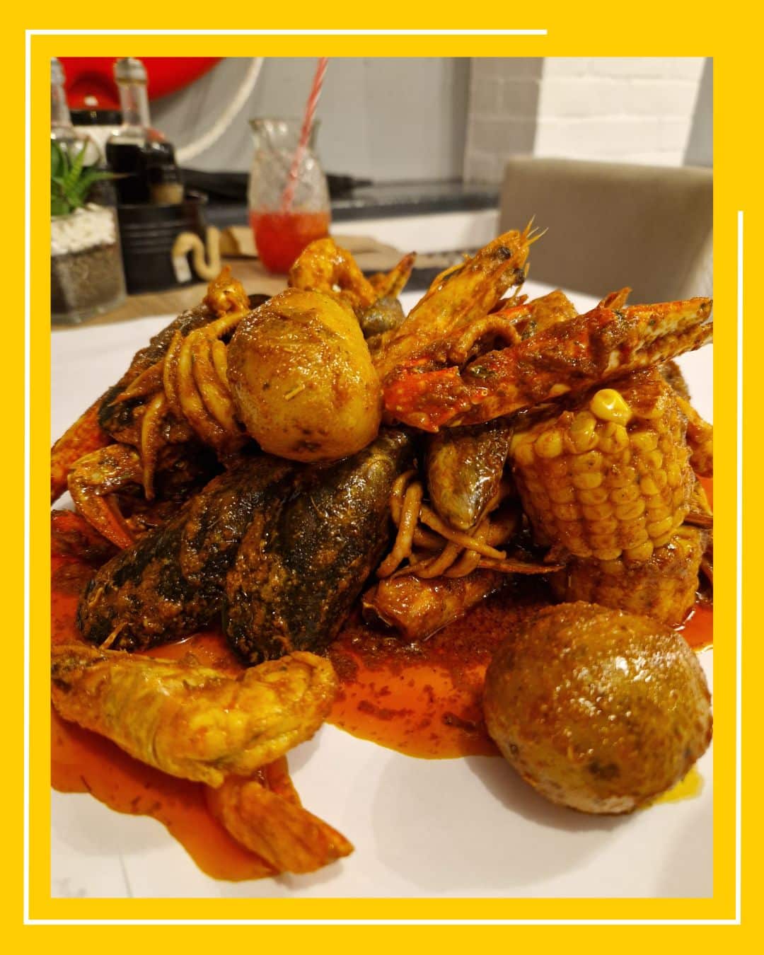 close up cu un morman de fructe de mare servit cu porumb si cartofi, si sos cajun