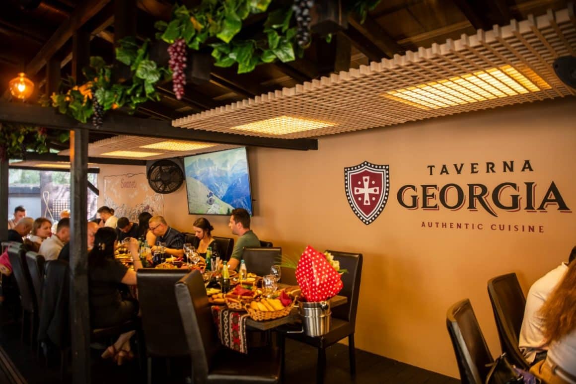 mai multi oameni iau masa pe terasa la Restaurant Taverna Georgia