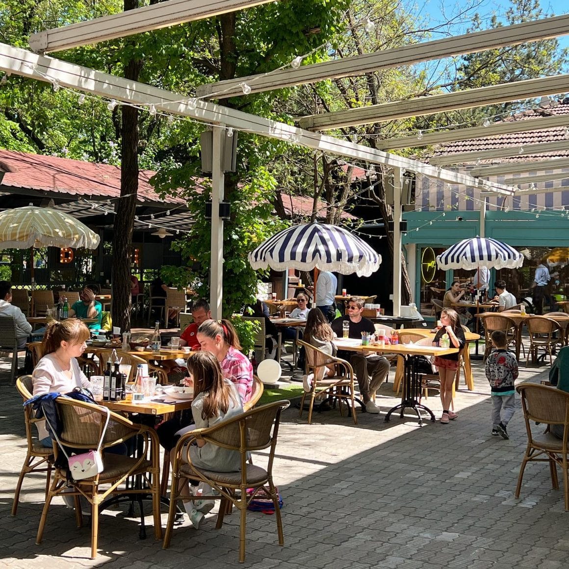 Terasa Stadio Park, cu mese asezate printre copaci. Terase Bucuresti pline de verdeata