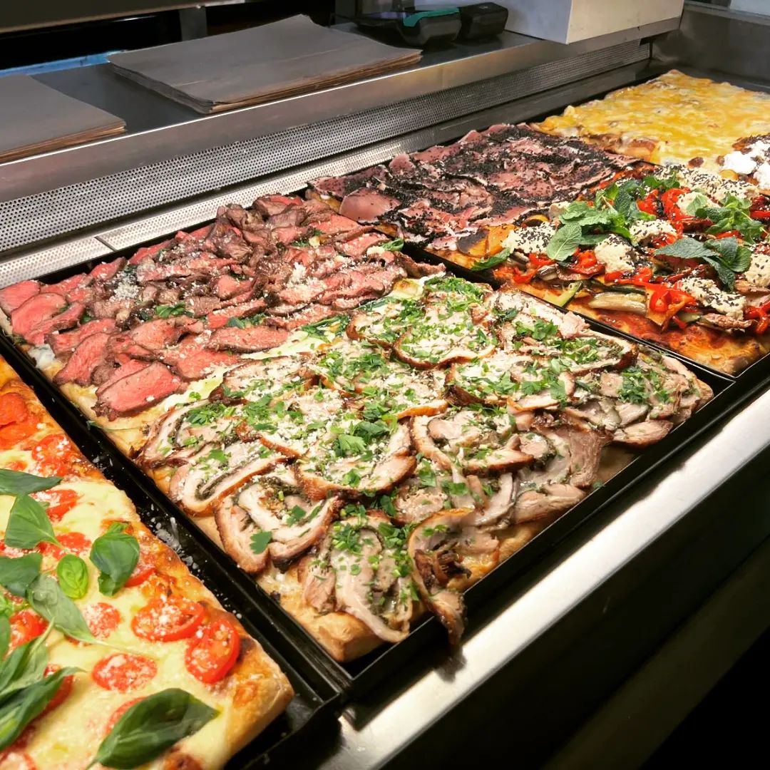 Mai multe tipuri de pizza la tava in vutrina la Buoni e Bravi. Cea mai bună pizza din București