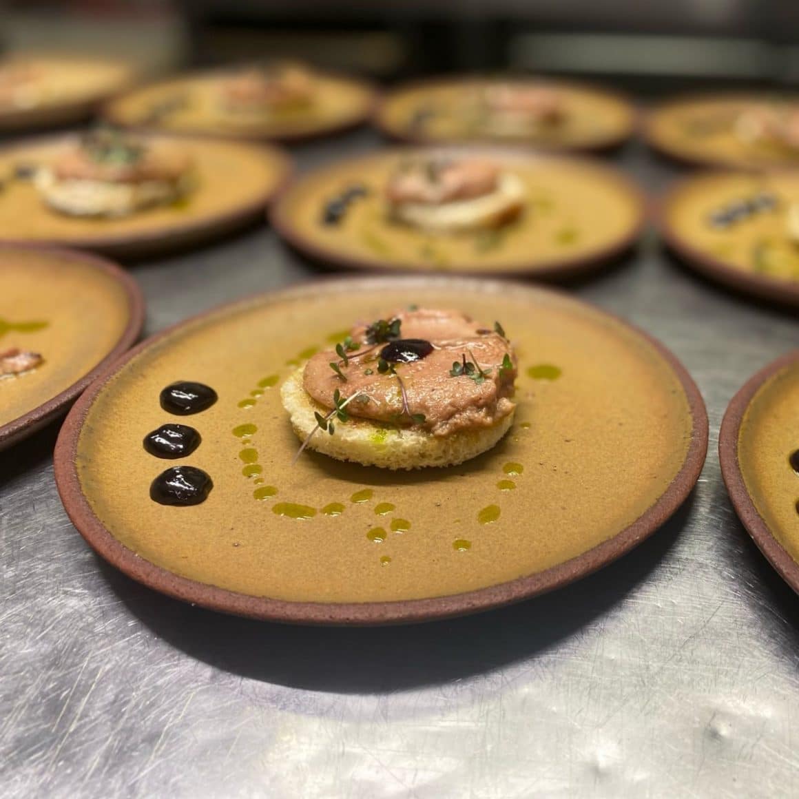 mai multe farfurii cu mancare, asezate in linie, cu blat si crema deasupra