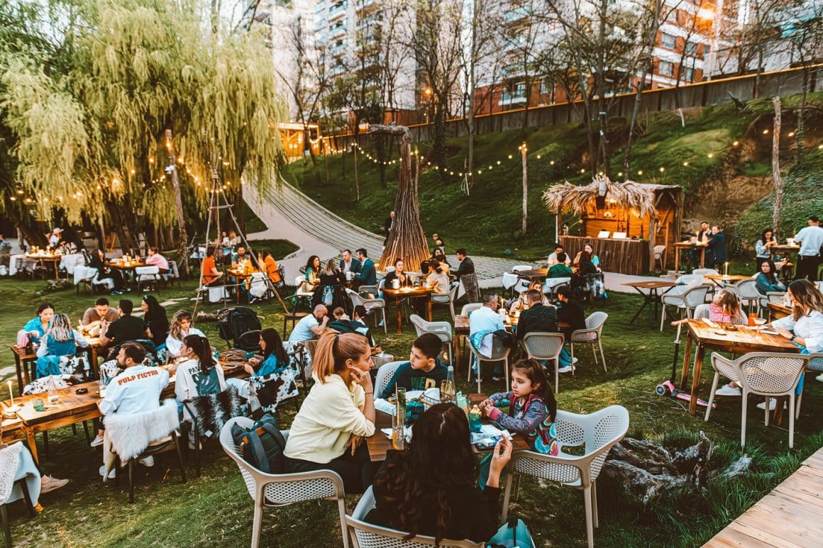 Terasa Indigen din București, intr-un decor cu copaci verzi si gazon