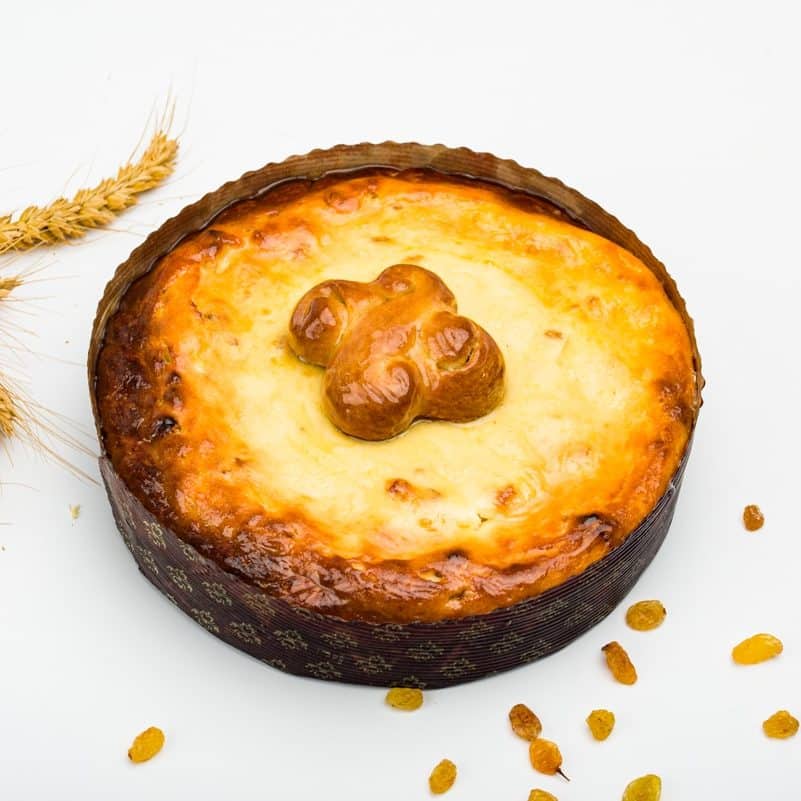 pască traditionala fotografiata pe fundal alb langa un spic de grâu