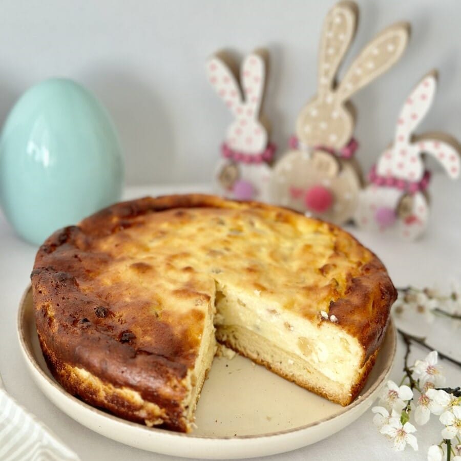 pasca din care este taiata o felie IAR IN fundal decora de paste cu oua si iepurasi