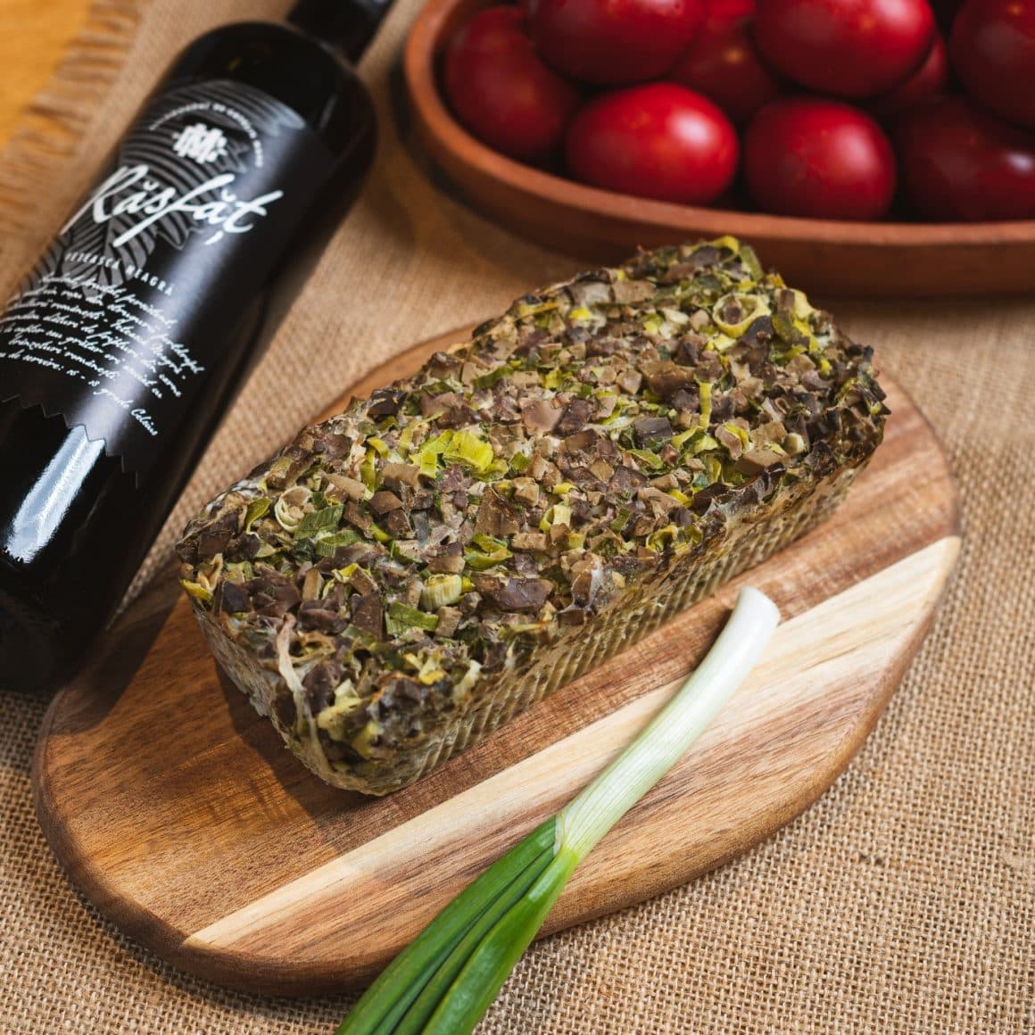 drob de miel alaturi de un platou cu oua rosii si o sticla de vin. Restaurante La Mama comandă masa de Paște