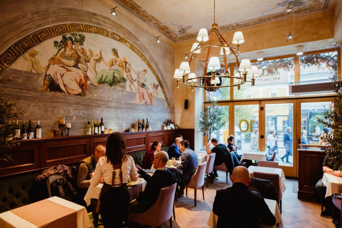 mai multi oameni iau masa la olivo. Restraurante Cluj