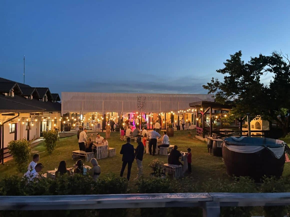 mai multi oameni iau masa si se relaxeaza seara, in gradina de la Vinalia - Conacul din Ceptura. Restaurante lângă București